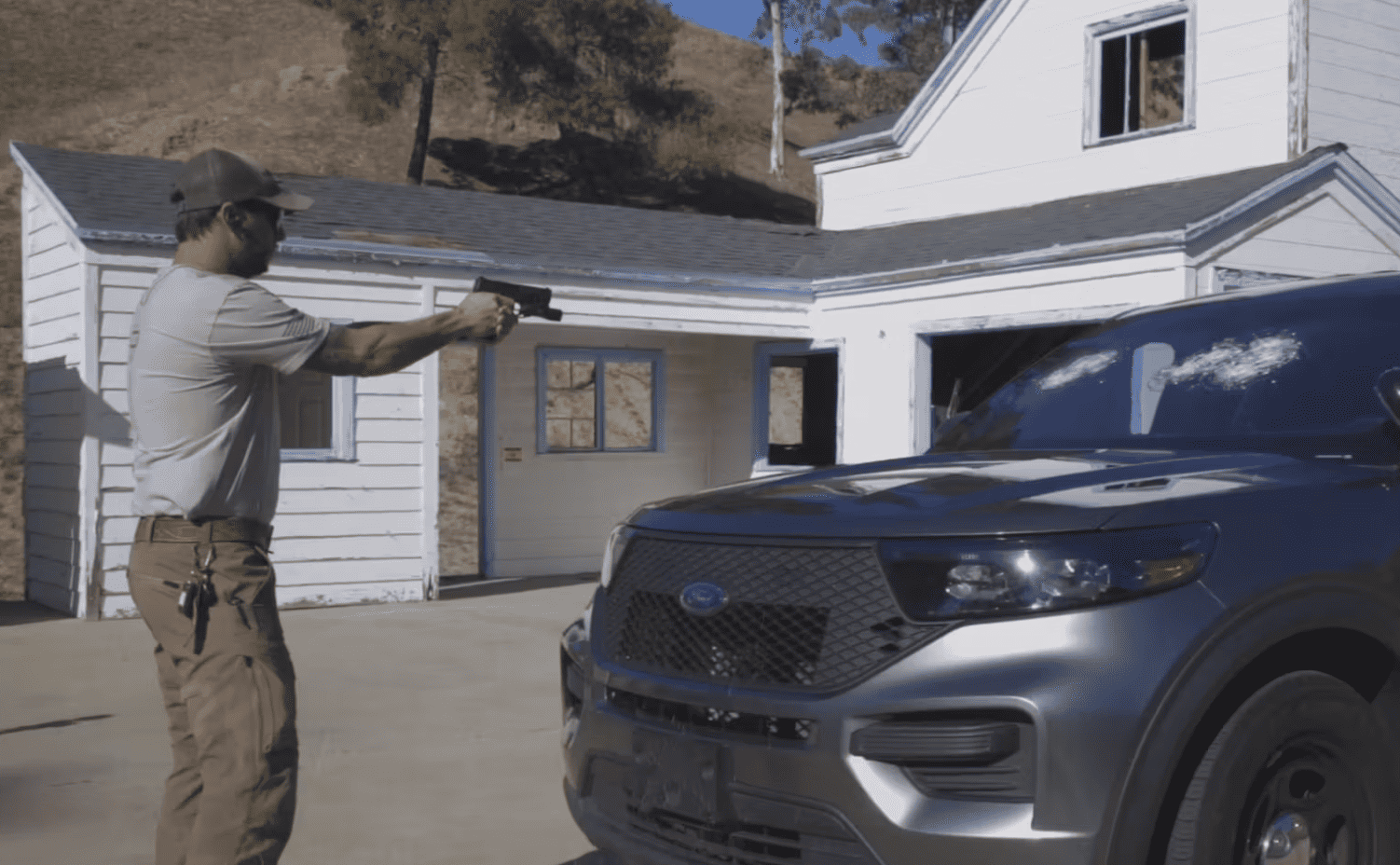 Man shooting the windshield of a car with a gun